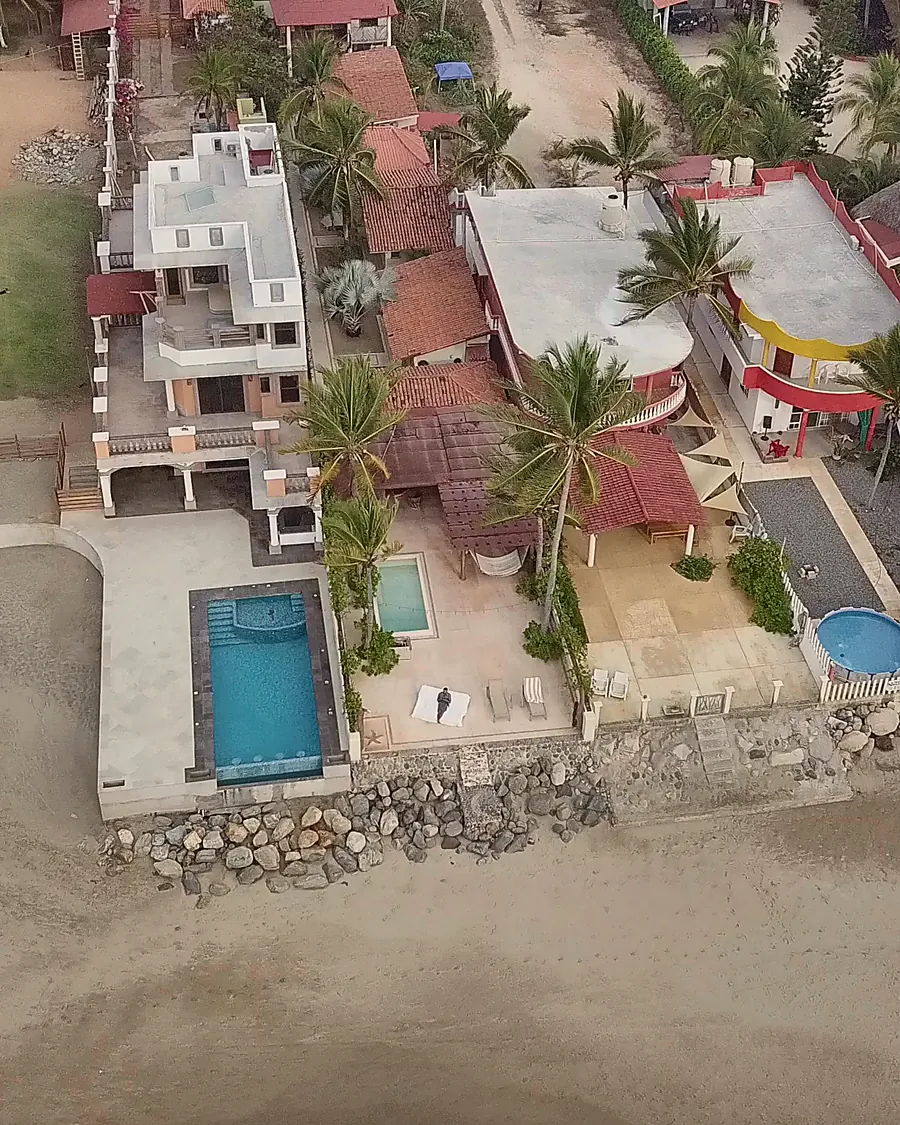 The property from over the beach: the pool terrace, the palapa, and the bungalows behind
